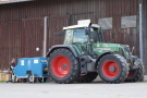 Ein Fendt Traktor mit einer Zapfwellenbremse vor einer Maschinenhalle 