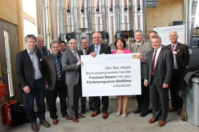 Gäste mit Staatssekretär Roland Weigert im Biomasseheizwerk in Niederaichbach