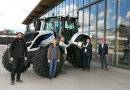 Die Projektbeteiligten stehen vor einem Valtra-Traktor