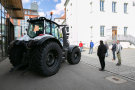 Personen stehen im Halbkreis um einen Traktor 