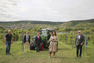 Landwirtschaftsministerin Kaniber mit vier Herren auf einem Weinberg. Im Hintergund ein Fendt-Traktor.