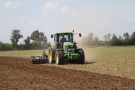 John Deere-Traktor bearbeitet mit Scheibenegge Ackerboden.