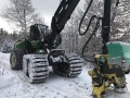 Harvester arbeitet im Winter bei Schneelandschaft.