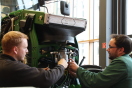 Zwei Mitarbeiter montieren Messtechnik am Kraftstofffilter eines John Deere.