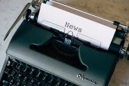 Das Foto zeigt einen dunkle Schreibmaschine mit einem Blatt Papier und der Aufschrift News