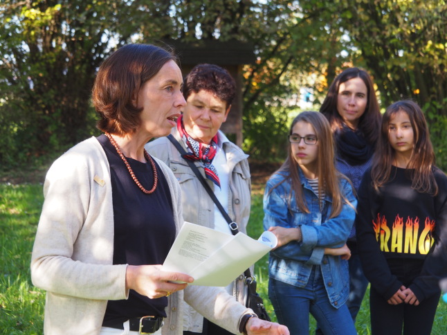 Annette Plank steht mit Gruppe im Garten