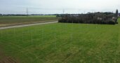 Das Foto zeigt etwa sechs Meter hohe senkrecht stehende Stützpfosten für die hoch aufgeständerte Agri-PV-Anlage.