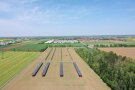 In der vertikalen Agri-PV-Anlage fräst ein Traktor die Parzellen für die landwirtschaftlichen Versuche. 