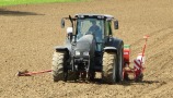 Schlepper bei der Saat von Silphie mit Hilfe eines Einzelkornsägeräts auf dem Feld