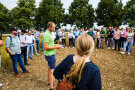 Menschen stehen im Kreis auf einem Feld