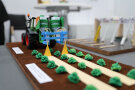 Miniaturmodell eines Traktors mit angeschlossenem Spezialgerät; Feld mit Salatköpfen