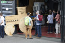 Zwei Unterhaltungen in Kleingruppen. Dahinter steht ein Traktor aus einer Holzplatte.