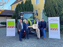 Vier Personen halten einen symbolischen Schlüssel aus Holz in der Hand 