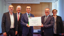 Bundesminister Cem Özdemir überreicht einen symbolischen Förderbescheid an das TFZ