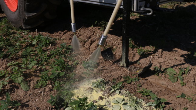 Maschine trägt spritzbares Mulchmaterial am Feld aus.