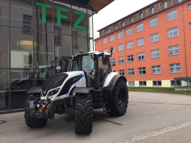 Traktor steht vor einer Häuserfassade 