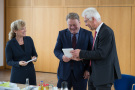 TFZ-Leiter Dr. Widmann (rechts) übergibt Birgit Keller (links) und Helmut Brunner (Mitte) ein Geschenk. 