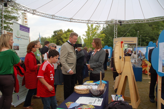 Umweltminister Marcel Huber wird am Infostand von einer Mitarbeiterin beraten. 