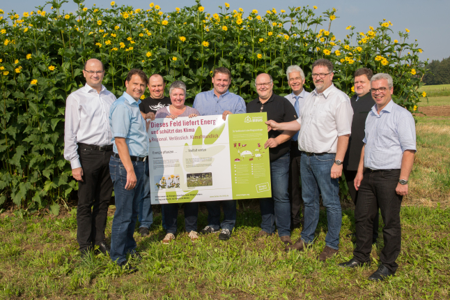 Im Bild überreicht der Fachverband Biogas den Betreibern einer Biogasanlage eine Infotafel, auf denen die Potenziale von Energiepflanzen erklärt werden.  