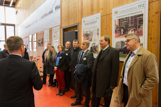 Sachgebietsleiter Dr. Remmele steht mit einer Besuchergruppe im Technikumsgang