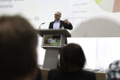 Redner steht gestikulierend am Rednerpult