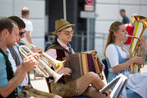 Musiker in Tracht spielen mit Trompeten, Akkordeon und Tuba