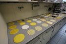 Runde Scheiben in gelblich, bräunlichen Tönen liegen angeordnet wie im Gitter auf Ablage im Labor