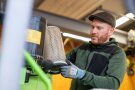Mann wechselt Filter bei Maschine aus