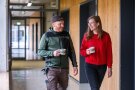 Mann und Frau gehen über Gang und unterhalten sich